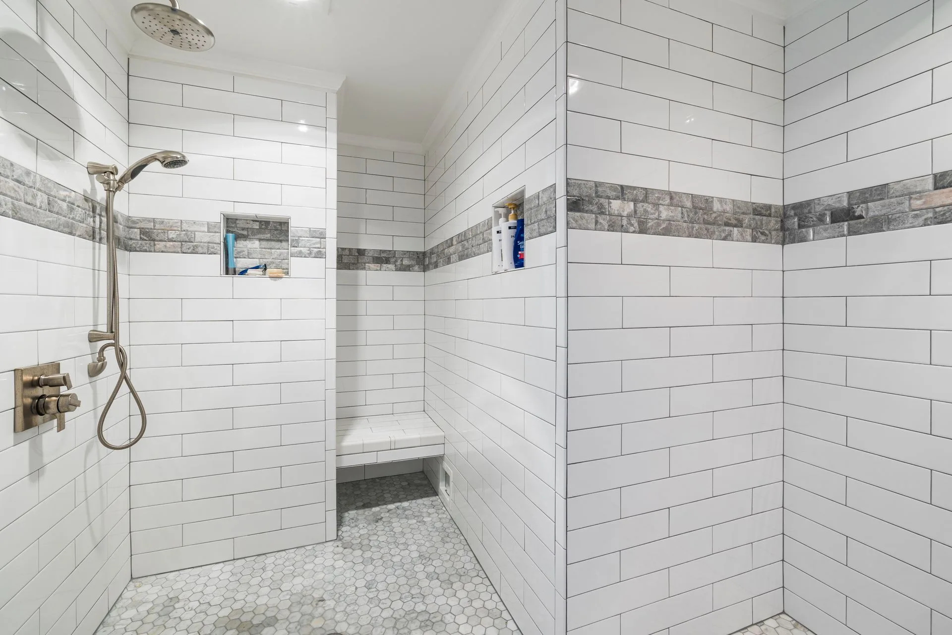White tiled walk-in shower with mosaic floor