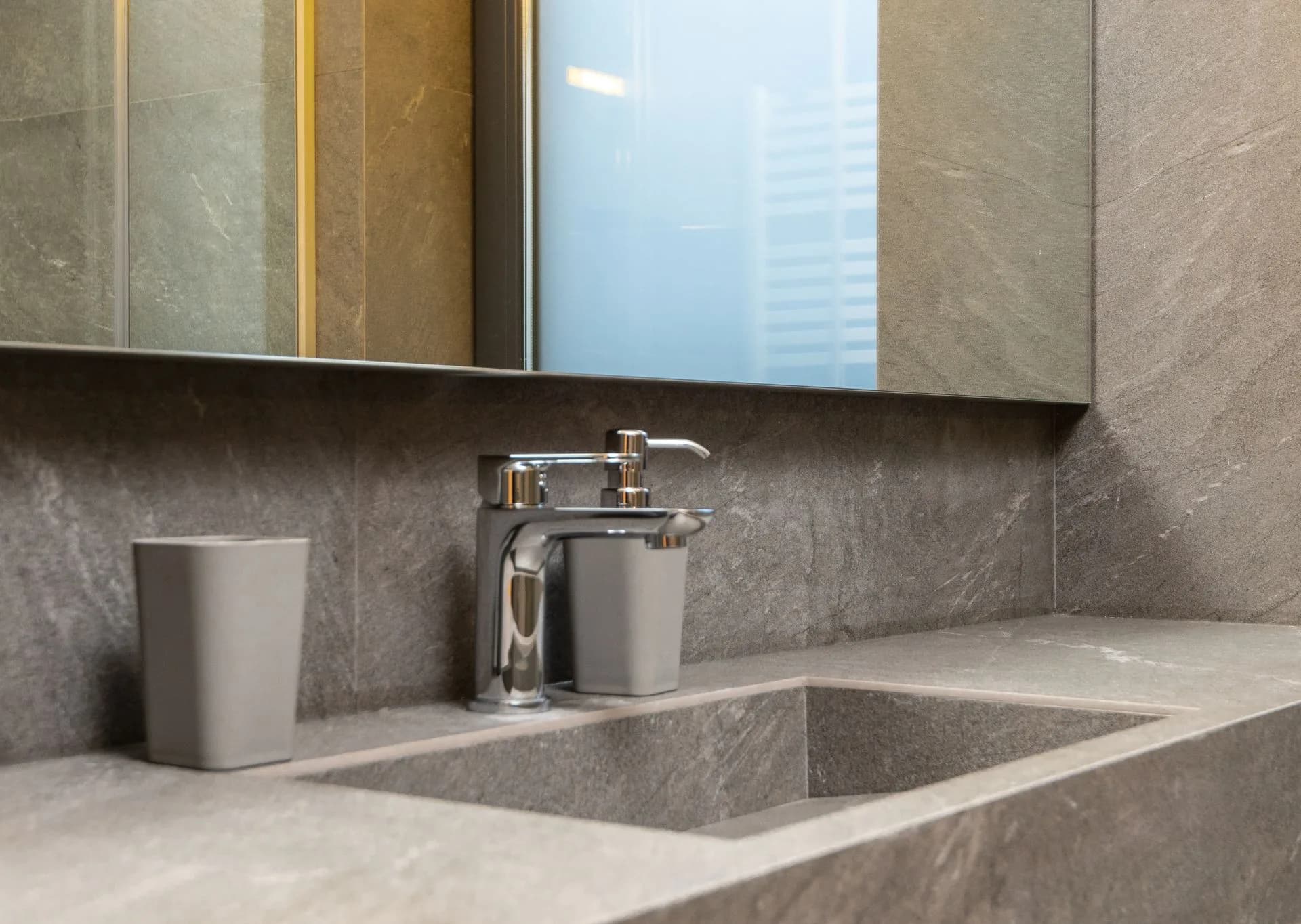Chrome faucet against marble tile in a contemporary bathroom