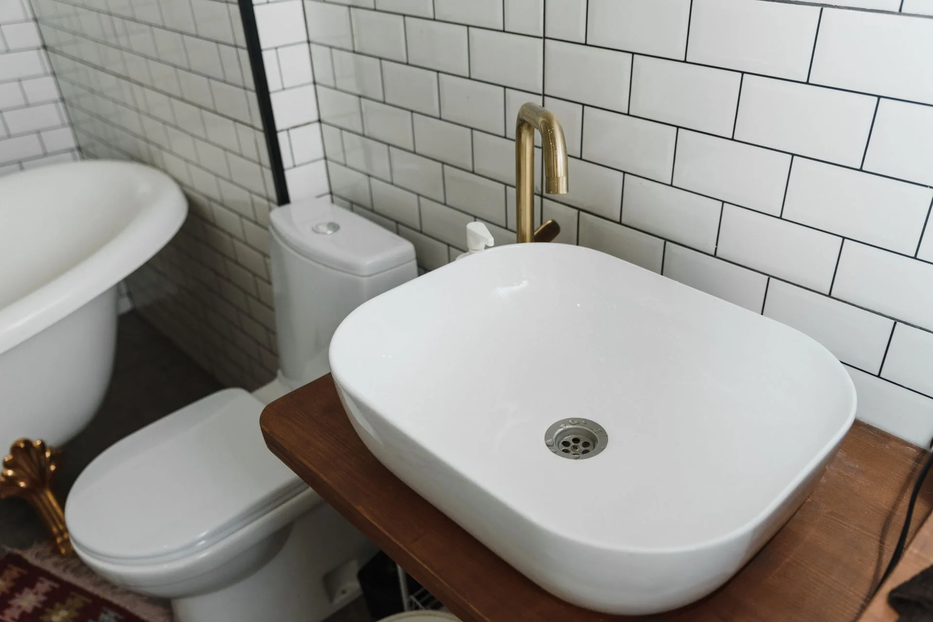 White bathroom with gold faucet and ceramic sink