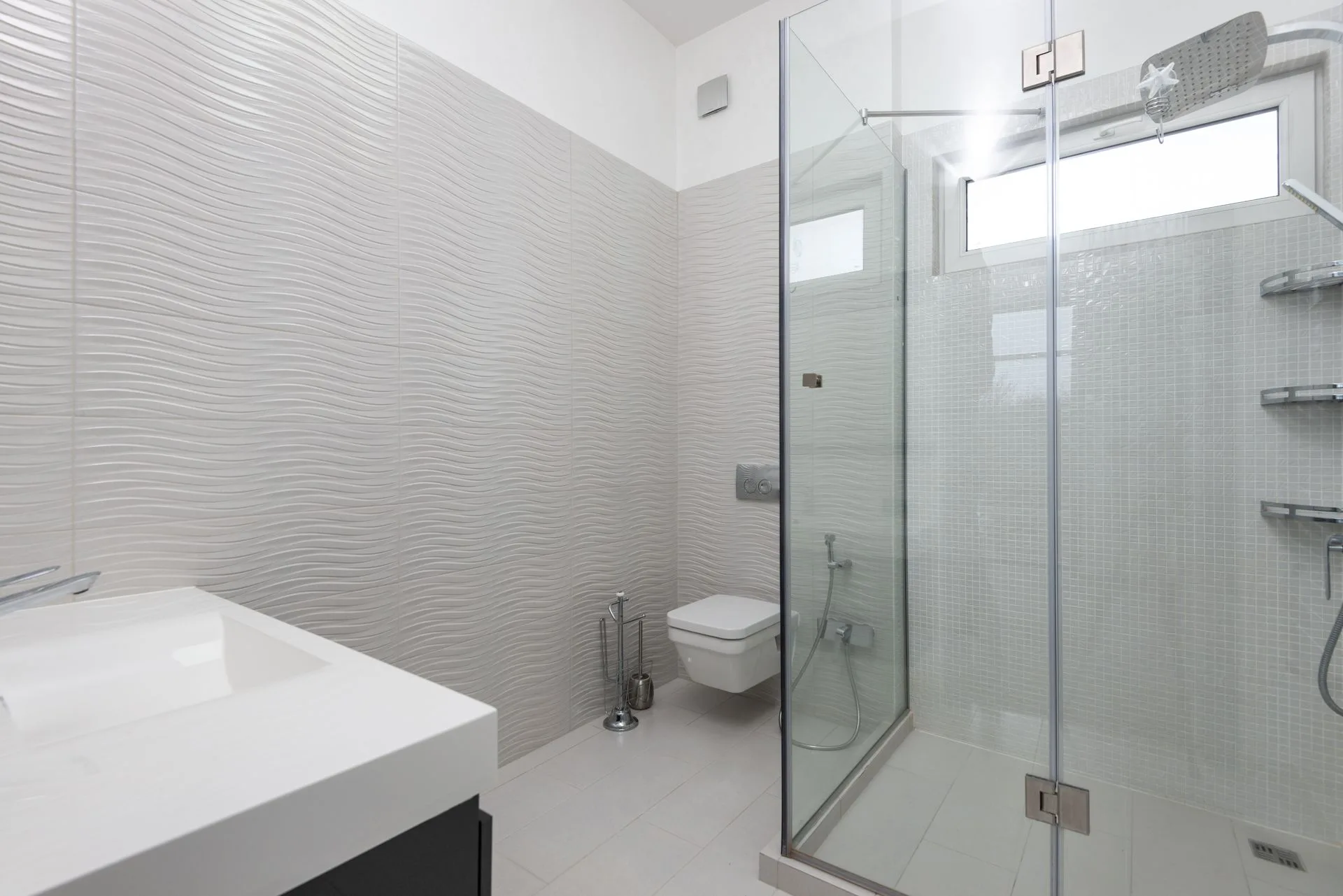 Modern bathroom with glass shower enclosure and textured walls