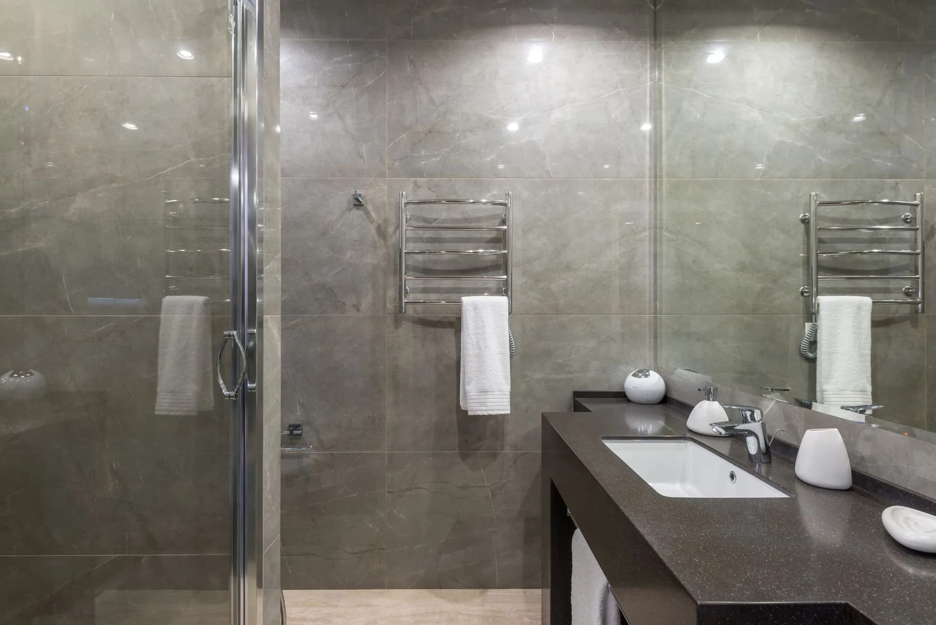 Modern bathroom with marble walls and glass walk-in shower