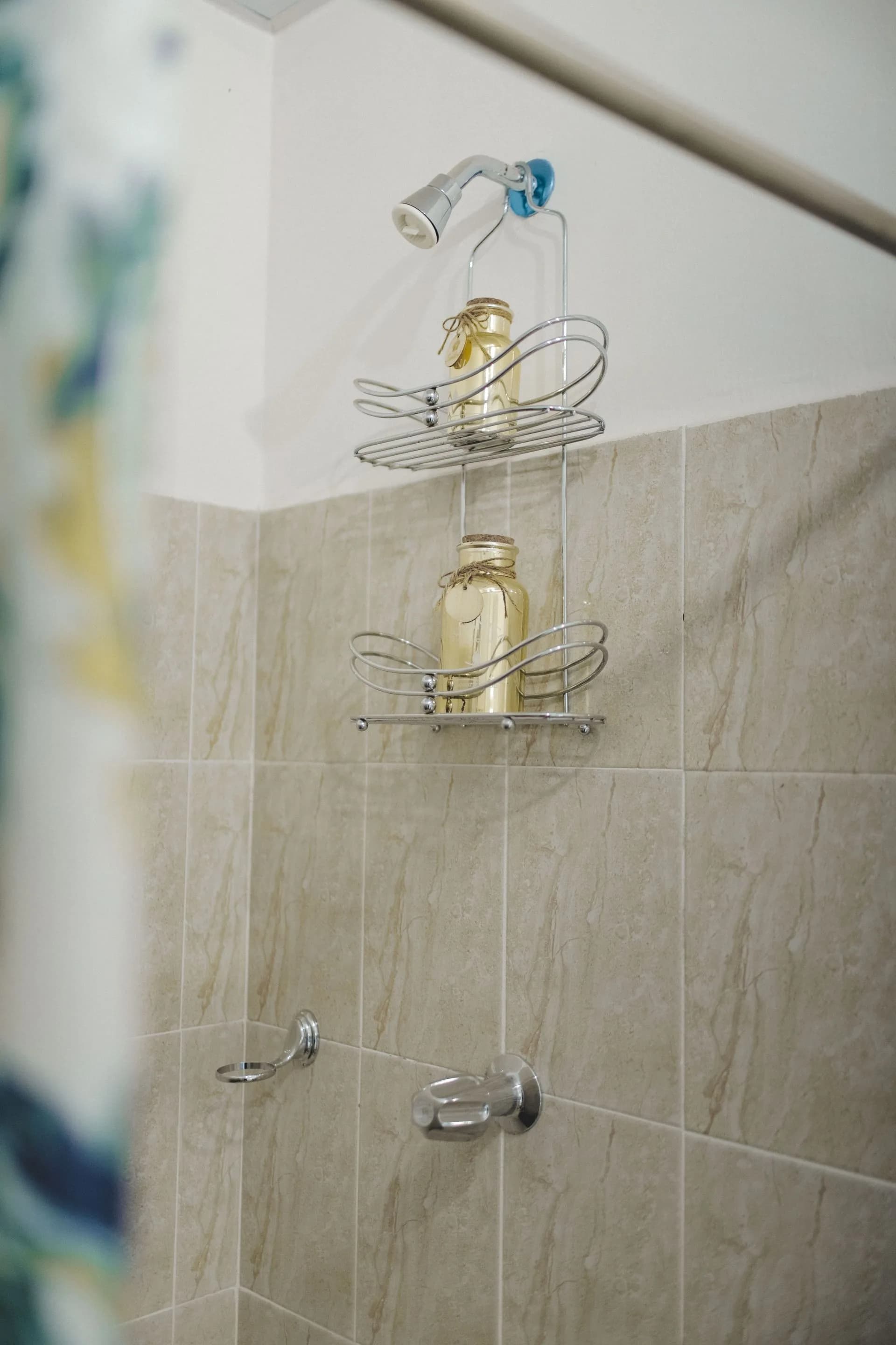 Tiled shower with wall-mounted shelf and showerhead